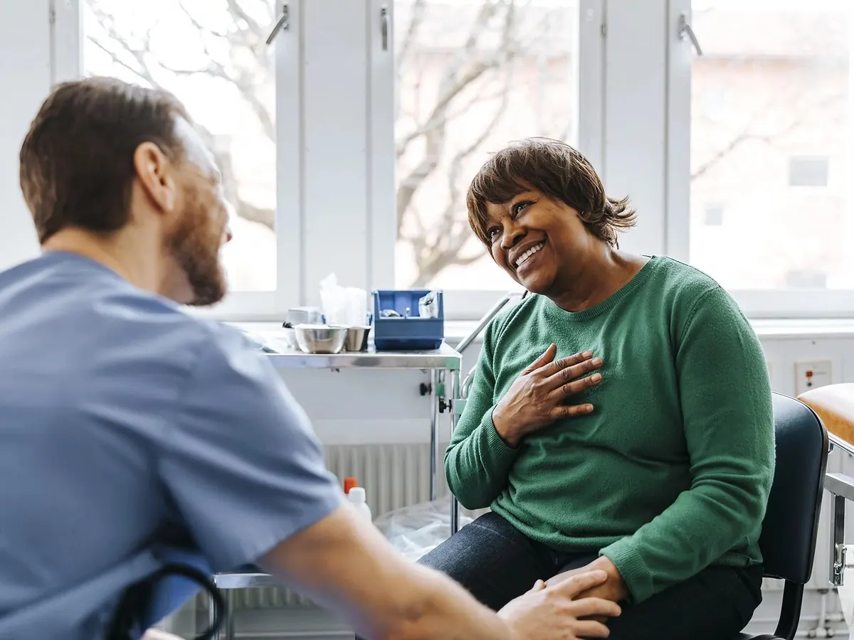 A patient smiling warmly with a community clinician during a consultation